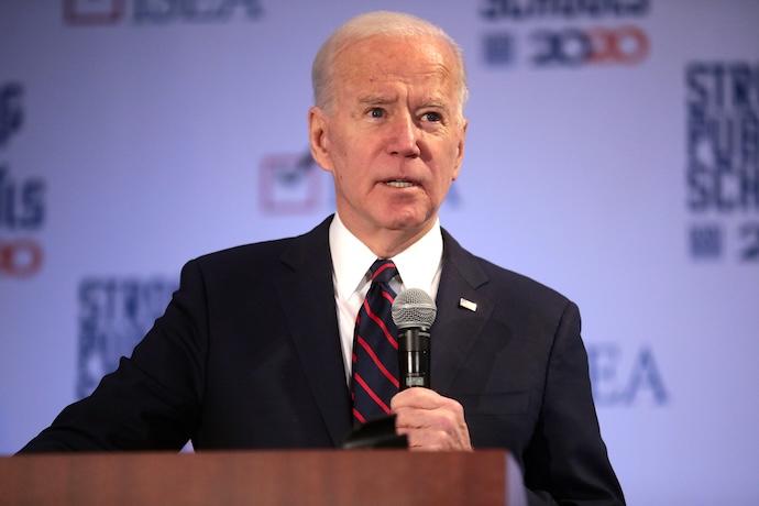 President Joe Biden at a podium with a microphone in hand.